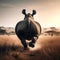 Back view of running rhino in African savannah grassland