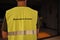 Back view of a safety profesional wearing  an emergency leader yellow vest.