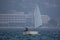 Back view of a sailor in a sailboat on a competition in Optimist class on open waters on the sea during sunny weather