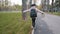 Back view schoolgirl walk on curb little girl with black backpack keep balance child going to school holding book in