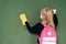 back view of schoolgirl wiping chalkboard with sponge while holding piece of chalk .