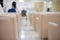 Back view and selective focus with copy space of seats with many people sitting for waiting for doctor in hospital lobby shows