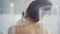 Back view of sensual woman washing shoulder in bath in slow motion.