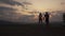 Back view on silhouettes of fitness muscular mixed race couple watching the sunrise in mountains together and holding