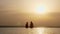 Back view, silhouettes, woman and teen girl, mom and daughter, sit on edge of outdoor infinity pool with panoramic sea