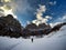 Back view of a skier skiing on a snow-covered landscape with immense rock formations in front