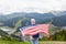 Back view of slender active tourist being fond of leisure activities, go hiking, holding U.S. flag, covering her back with it,