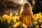 Back view of small girl child in field of yellow Daffodil spring flowers