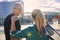 Back view of sportive middle aged couple, tennis players with tennis racket standing together outdoors, ready for