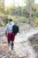 Back view of a sportsman walking with a black backpack after finishing the workout in nature