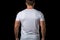 back view of sportsman in white tshirt on black background, Male model wearing a white half sleeves tshirt on a Black background,