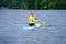 Back view of a sporty girl with white hair sitting on a board with a paddle on the river