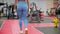 Back view of sporty woman doing lunge exercise in gym