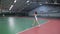 Back view of sporty woman playing tennis and hitting ball with racket