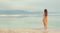 Back view of stylish girl wearing dress on seaside, Dead Sea beach. Travel, summer vacation, holiday, freedom concept. Digital