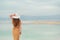 Back view of stylish girl wearing dress on seaside, Dead Sea beach. Travel, summer vacation, holiday, freedom concept. Digital