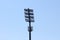 Back view of tall stadium metal column filled with reflectors in various sizes and cell phone antennas and transmitters