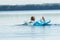 Back view of teenager paddling with his arms and floating on blue pool lilo outdoors