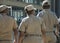 Back view of three south african traffic officers, one female and two males, wearing caps