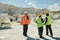 Back view of three workers of marble quarry moving down territory of factory