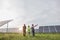 Back view of three workers walking on solar station