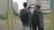 Back view of three young boys dressed in 1980s style entering outdoor sport court. Camera follows cheerful multiethnic