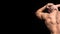 The back view of torso of attractive male body builder on dark background.