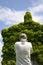 Back view of a tourist photographing an old ivy-covered church in countryside in a summer day - Concept of nature recovering its