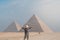 back view of tourist woman standing in front of pyramids. Egypt, Cairo - Giza