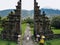 Back view of Tourist woman walking through Traditional Balinese Hindu gate Candi Bentar close to Bedugul, Bratan lake