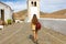 Back view of traveler girl walking in small colonial town of Betancuria, Canary Islands, Spain