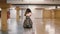 Back view of traveler woman legs walking with a suitcase in the airport. Girl with backpack flies on vacation.