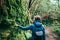 Back view of traveler woman walking in forest