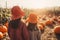 Back view of two children in seasonal pumpkin patch