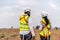 Back view of two engineers african american man and woman in uniform discuss and use tablet working with wind turbine model at