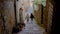 Back view of a two girls going down a narrow Venice street holding hands, child happy girls.