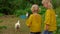 Back view of two little girls looking at the chickens walking in the backyard