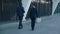 Back view on the two multiethnic businessmen in formal suits walking the street in the modern business city and talking