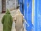 A back view of two people, wearing sweaters with conical hoodies walking on the rural streets during winters.