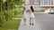 Back view of two stylish women in white walking on pavement and talking.