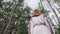 Back view of ukrainian woman stands in fir forest, Carpathian mountains nature. Girl in traditional embroidery