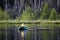 Back view of an unknown man fly-fishing using a float tube