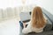 Back view of unrecognizable mature woman using laptop while sitting on comfortable sofa