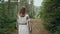 Back view of unrecognizable ukrainian woman walking in fir forest, Carpathian mountains nature. Girl in traditional