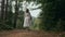 Back view of unrecognizable ukrainian woman walking in fir forest, Carpathian mountains nature. Girl in traditional