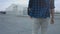 Back view of a walking guy wearing a plaid shirt and jeans. Walking in an epic manner, walking confident. Slow motion.