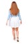 Back view of walking woman in dress. beautiful redhead girl in