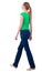 Back view of walking woman in jeans and shirt.