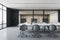 Back view on white meeting table surrounded by grey wheel chairs on concrete floor in stylish conference room with glass wall