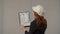 Back view of a woman architect with a apartment plan on a clipboard. A business woman studies the project plan, prepares